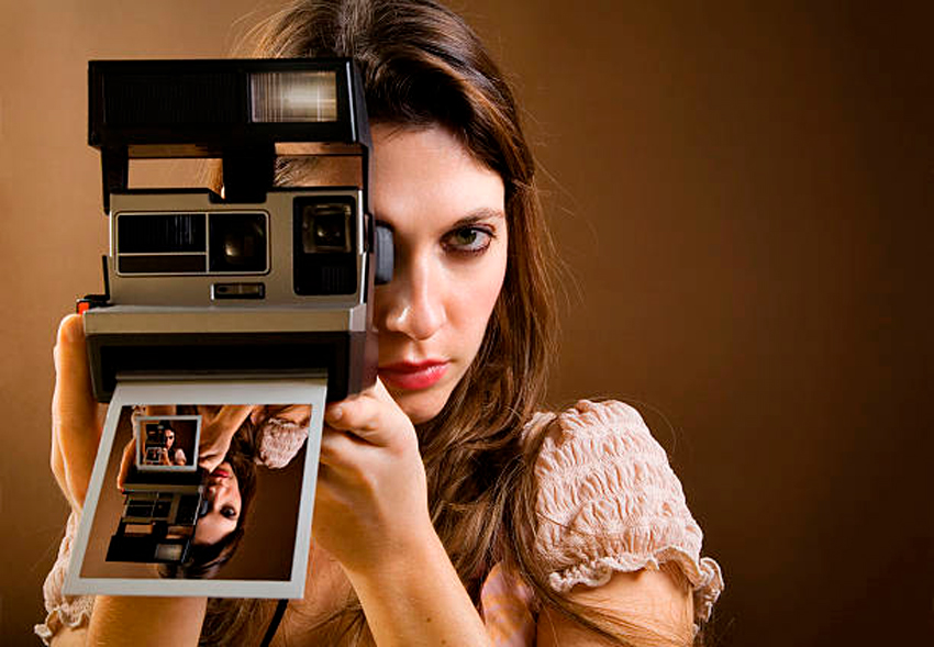chica haciendo foto con una cámara Polaroid